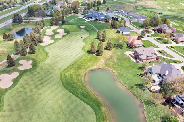 aerial view of property's location featuring a large body of water, a golf course, and nearby suburban area