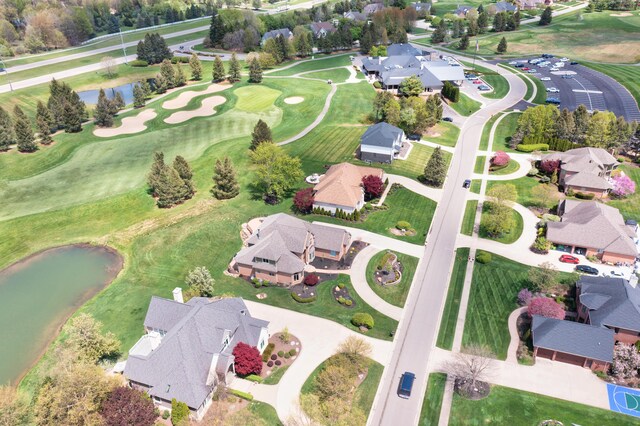 aerial view of residential area featuring a nearby body of water and a golf club