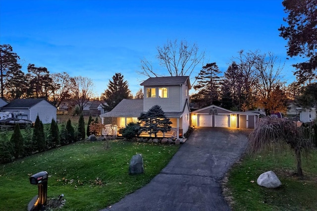 traditional-style home featuring an outbuilding, a front yard, and aphalt driveway