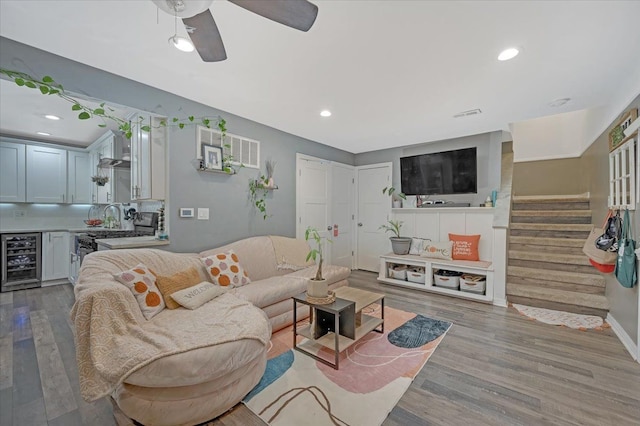 living room featuring wine cooler, recessed lighting, ceiling fan, wood finished floors, and stairway