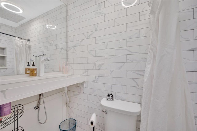 full bathroom with toilet, tile walls, and a shower with shower curtain