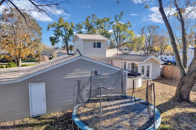back of house with fence, a trampoline, and french doors