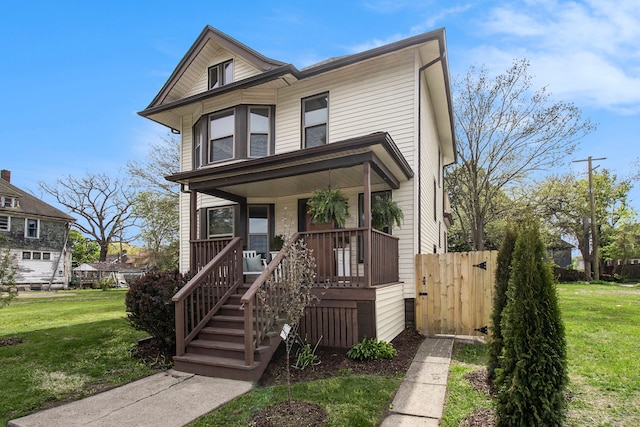 view of front of home featuring a porch, a front lawn, and fence