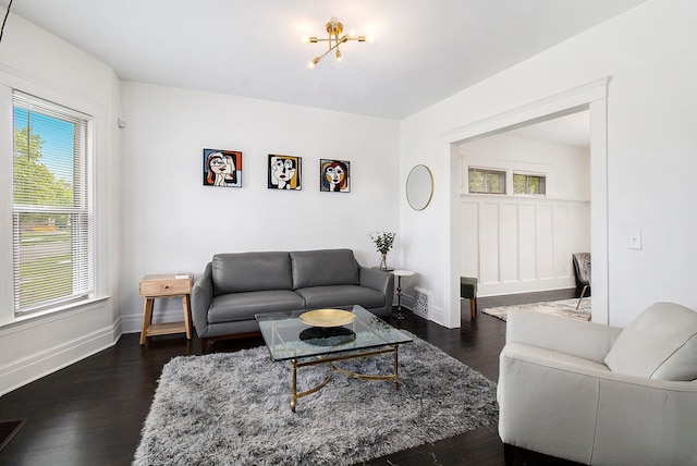 living room featuring visible vents, dark wood-style flooring, and baseboards