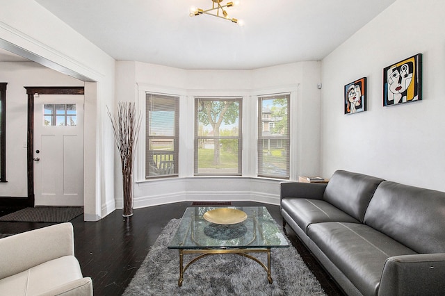 living room with dark wood-style flooring, baseboards, and a chandelier