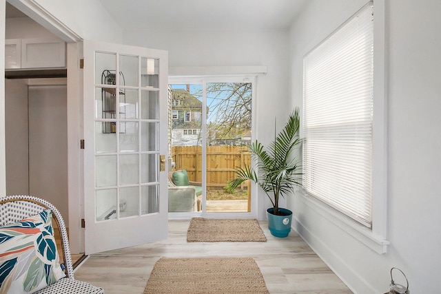 doorway to outside featuring baseboards and wood finished floors