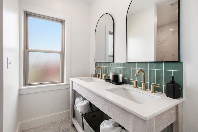 bathroom with backsplash, visible vents, a sink, and double vanity