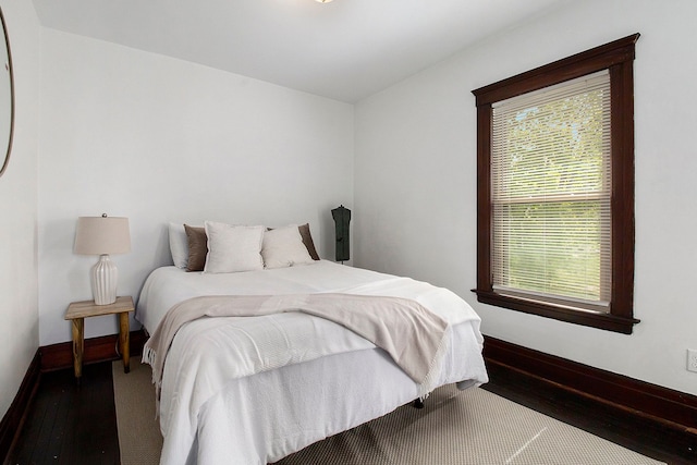 bedroom featuring baseboards, multiple windows, and hardwood / wood-style flooring
