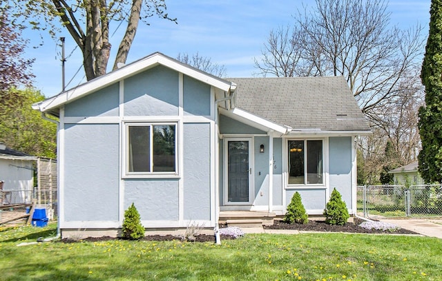 bungalow with stucco siding and a shingled roof