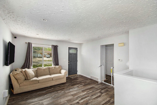 living room featuring wood finished floors, a textured ceiling, and baseboards
