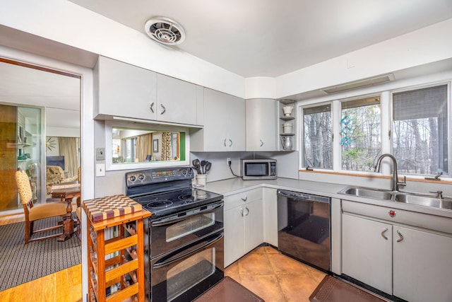 kitchen featuring light tile patterned floors, a sink, open shelves, black appliances, and light countertops