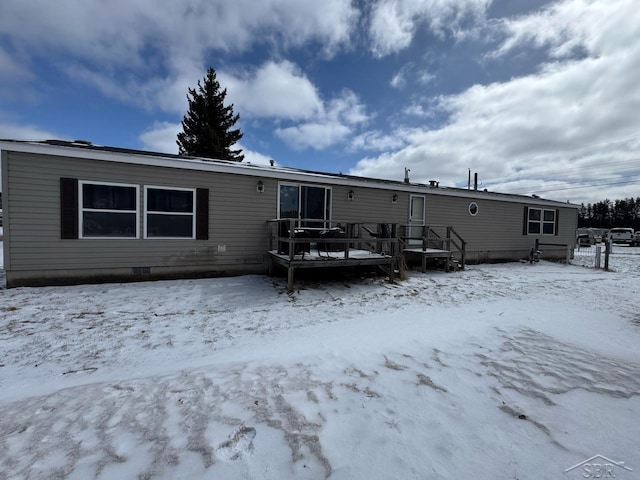 snow covered property featuring crawl space and a deck