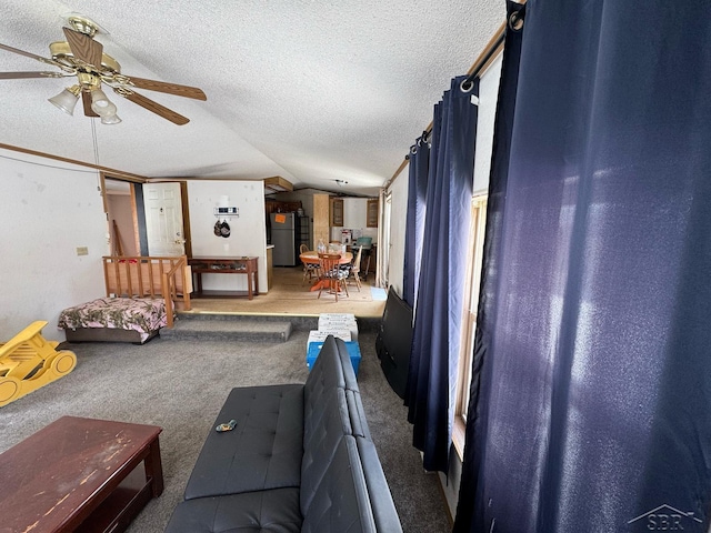 living room featuring vaulted ceiling, ceiling fan, a textured ceiling, and carpet