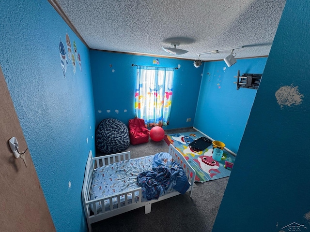 carpeted bedroom featuring a textured ceiling and a textured wall