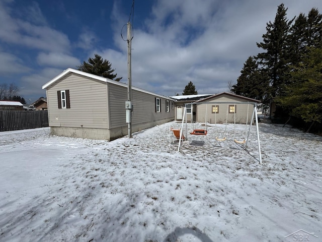 snow covered rear of property with fence