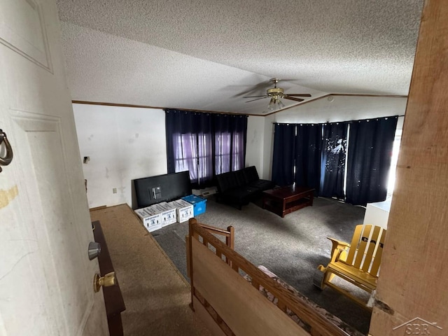 living room featuring carpet flooring, a textured ceiling, vaulted ceiling, and a ceiling fan