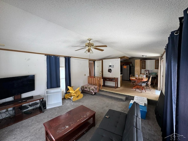 carpeted living area featuring a textured ceiling, vaulted ceiling, and a ceiling fan
