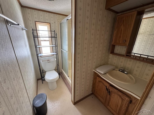 full bathroom featuring a stall shower, toilet, baseboards, vanity, and crown molding
