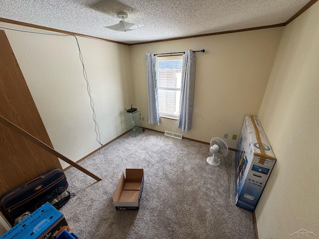 miscellaneous room featuring carpet flooring, a textured ceiling, visible vents, and ornamental molding