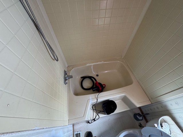 full bathroom with  shower combination, tile walls, and toilet