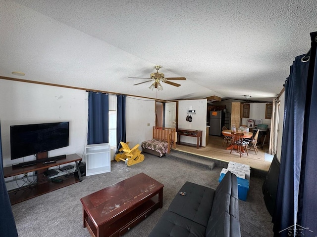 living room with a textured ceiling, lofted ceiling, a ceiling fan, and carpet floors