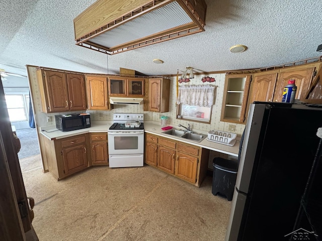 kitchen with a sink, freestanding refrigerator, a textured ceiling, black microwave, and white range with electric cooktop