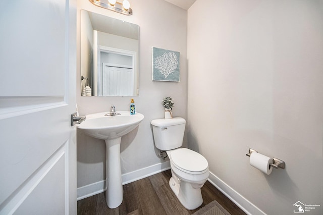 809 Sarah Ln, Milan, MI 48160 - half bathroom with toilet, wood finished floors, baseboards, and a sink