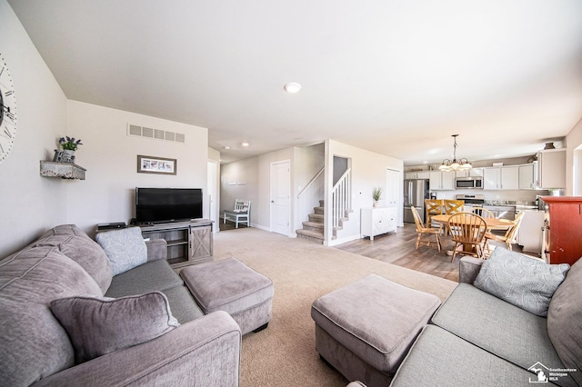 809 Sarah Ln, Milan, MI 48160 - living area with visible vents, recessed lighting, stairway, an inviting chandelier, and baseboards