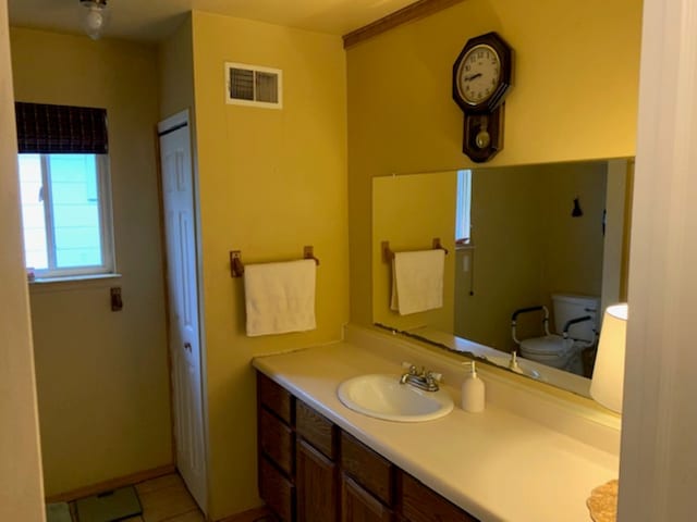 bathroom with vanity, toilet, visible vents, and tile patterned floors