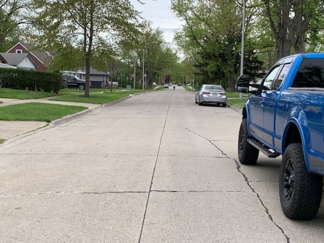 view of street featuring curbs, sidewalks, and street lights