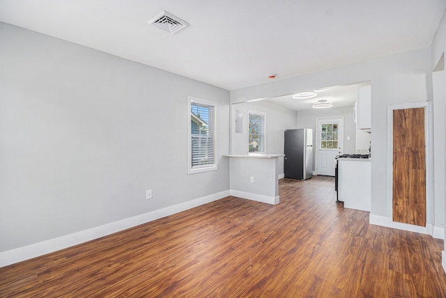 604 Montana Ave, Pontiac, MI 48341 - unfurnished living room with baseboards, dark wood finished floors, and healthy amount of natural light