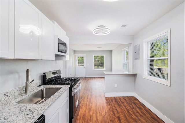 604 Montana Ave, Pontiac, MI 48341 - kitchen with stainless steel range with gas cooktop, a sink, dark wood-type flooring, white cabinets, and baseboards