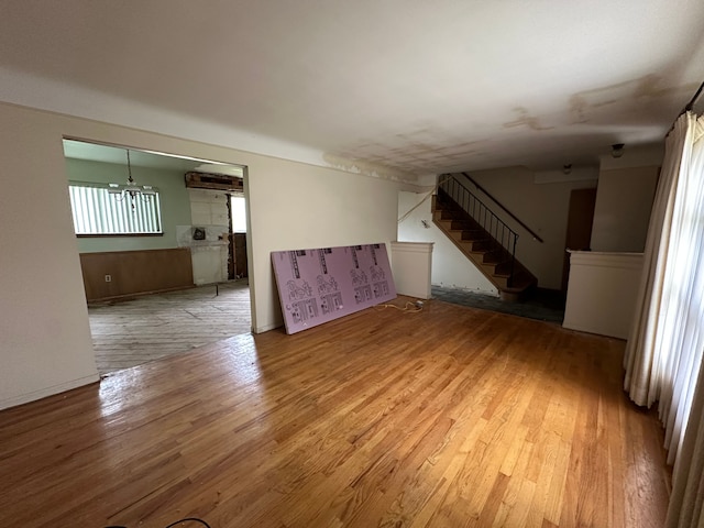 unfurnished living room with stairway and wood finished floors