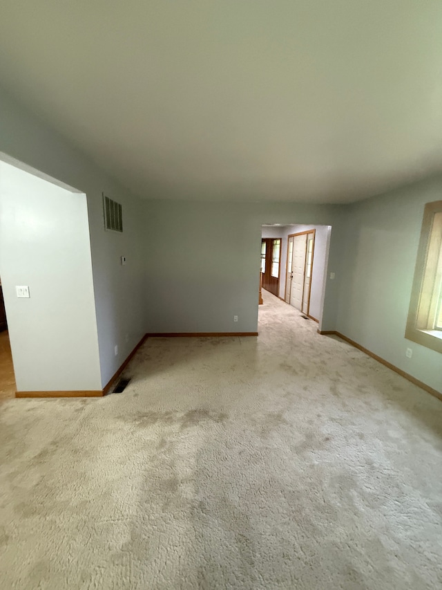 carpeted spare room with baseboards and visible vents