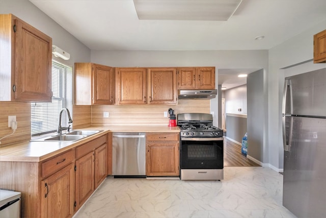 kitchen featuring stainless steel appliances, under cabinet range hood, light countertops, light marble finish floors, and recessed lighting