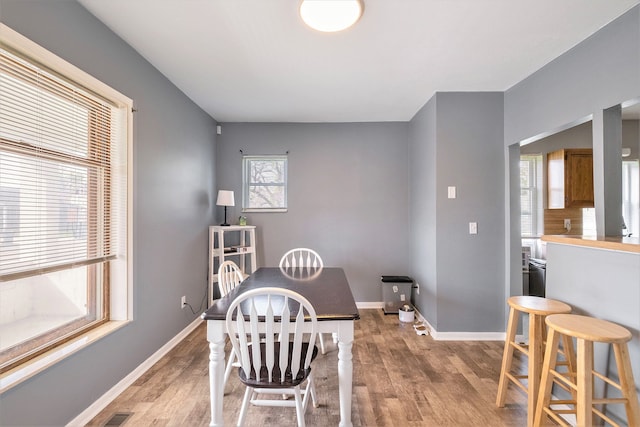 dining room featuring light wood-style flooring and baseboards