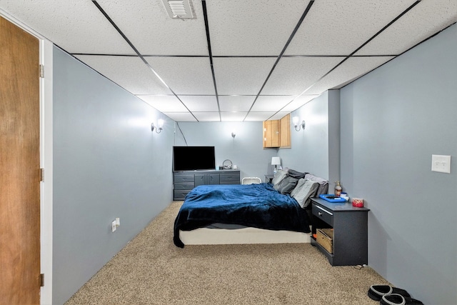 carpeted bedroom with a drop ceiling
