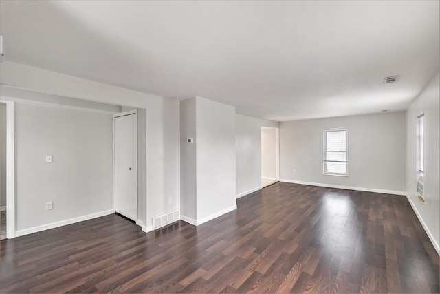 empty room featuring dark wood-style flooring and baseboards
