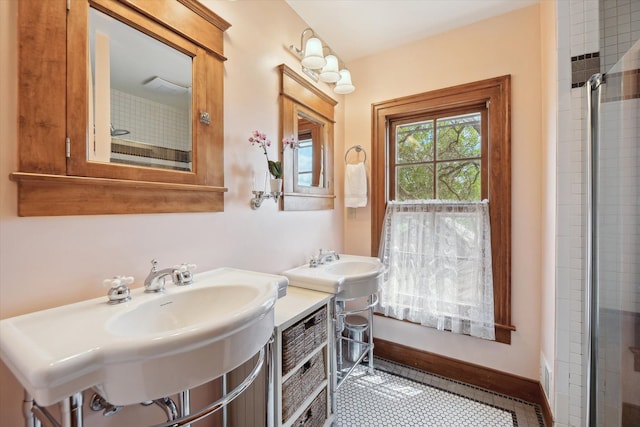 bathroom featuring a sink, a tile shower, and tile patterned flooring