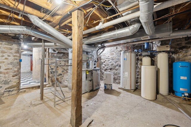 unfinished below grade area featuring water heater, a water pressure tank, and a water softener