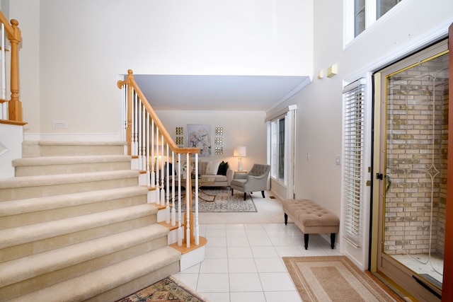 entrance foyer featuring baseboards, light tile patterned flooring, and stairs