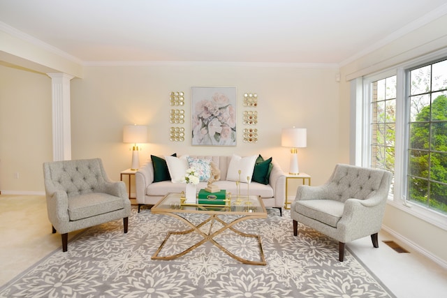 carpeted living area featuring ornamental molding, a healthy amount of sunlight, visible vents, and decorative columns