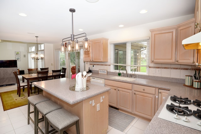 kitchen featuring light countertops, a wealth of natural light, light brown cabinets, and a sink