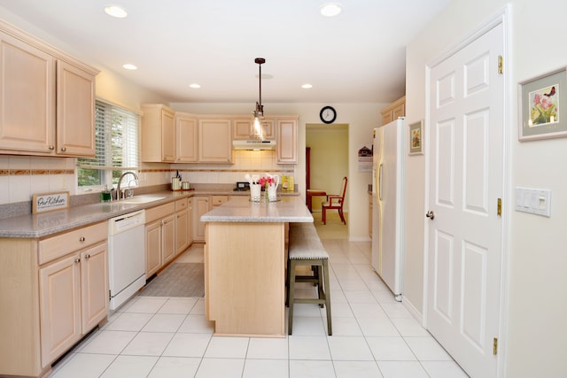 kitchen featuring a sink, white appliances, tasteful backsplash, light countertops, and a center island