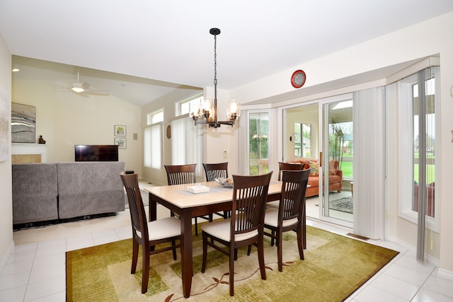 tiled dining space with lofted ceiling, ceiling fan with notable chandelier, and baseboards