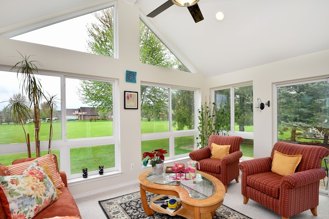 sunroom with a ceiling fan, baseboards, and high vaulted ceiling