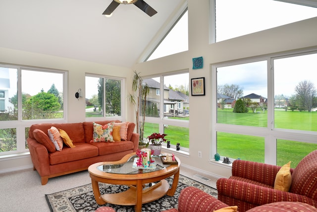 sunroom / solarium with high vaulted ceiling, baseboards, a ceiling fan, and visible vents