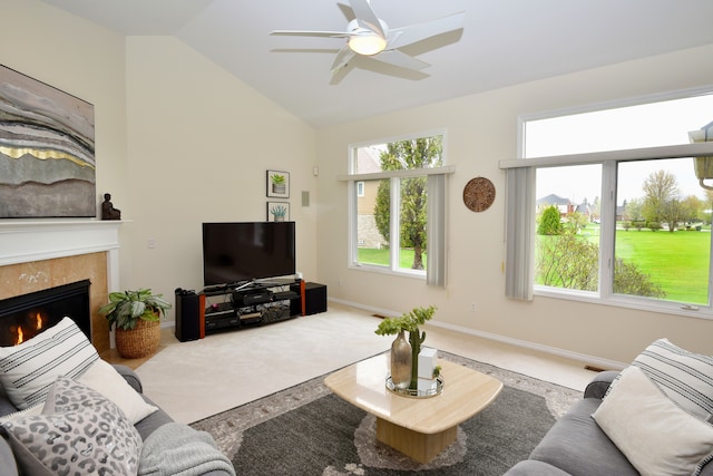 living area featuring plenty of natural light, a fireplace, a ceiling fan, and carpet floors