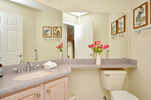 bathroom featuring toilet and vanity