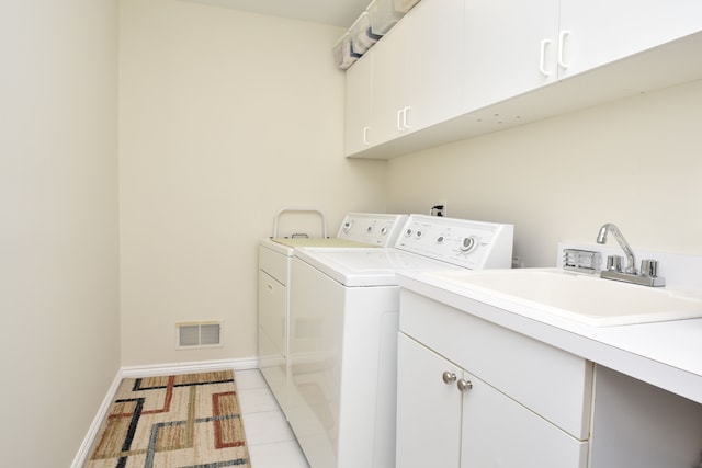 laundry area with a sink, cabinet space, visible vents, baseboards, and independent washer and dryer